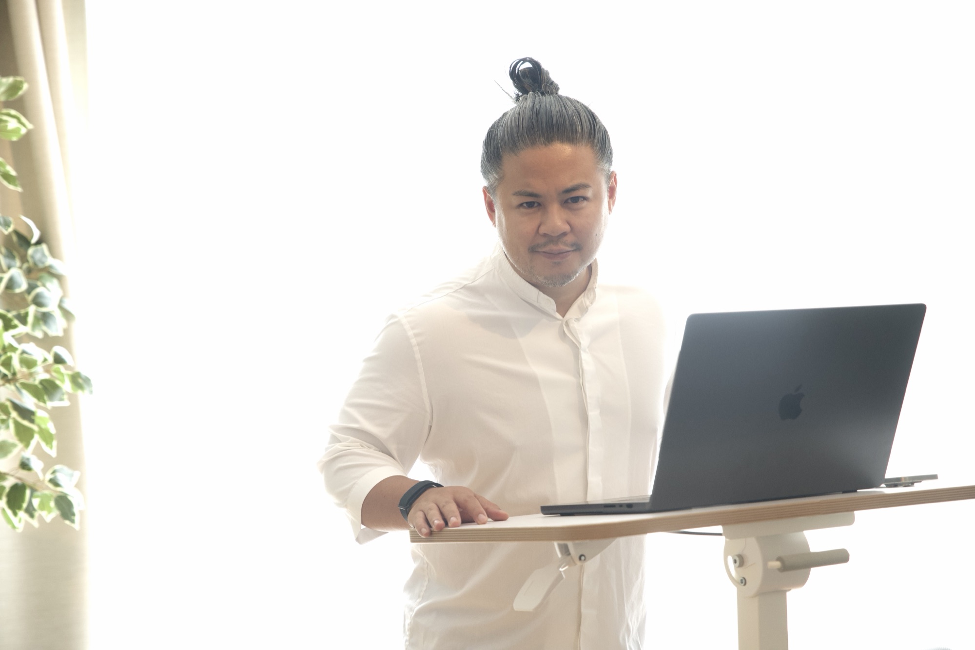 Jay Manuzon am Stehpult mit Laptop, Blick in die Kamera